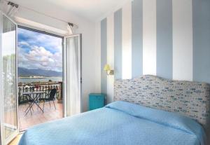 1 dormitorio con cama y vistas a un balcón en Hotel Sette Archi, en Bocca di Magra