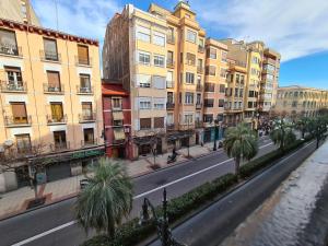 eine Straße mit Gebäuden und Palmen in einer Stadt in der Unterkunft Dos Torres Boromir - Ubicación en el Corazón de la Ciudad in Saragossa