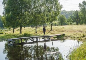 una persona caminando a través de un puente sobre un estanque en Hunseröds Bed & Breakfast, en Perstorp
