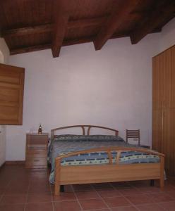 - une chambre avec un lit en bois et une commode en bois dans l'établissement Agriturismo San Fele, à Cerchiara di Calabria