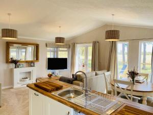 a kitchen with a sink and a living room at Hollicarrs - Wildflower Lodge in York
