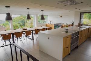 uma cozinha com um balcão e uma mesa com cadeiras em Genieten in La Roche em La-Roche-en-Ardenne