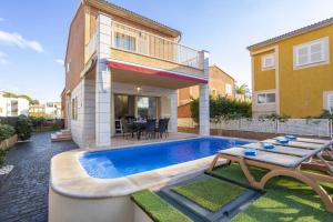 a backyard with a swimming pool and a house at Villa Playera in Alcudia