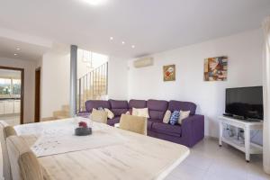 a living room with a purple couch and a table at Villa Playera in Alcudia