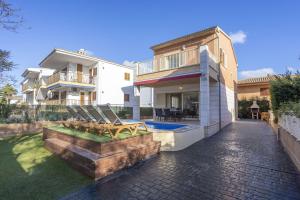 a house with a patio and a swimming pool at Villa Playera in Alcudia