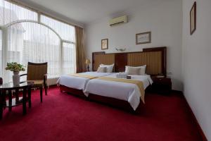 a hotel room with a large bed and a table at Garni Hotel Planeta Inn in Novi Sad