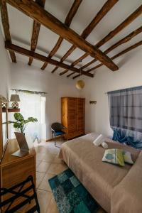 a bedroom with a bed and a chair in a room at Case Vacanza Cafarella in Malfa