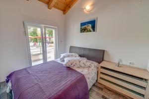 a bedroom with a bed and a wooden dresser at Veli rat apartments in Savar