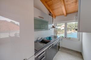 a kitchen with a sink and a window at Veli rat apartments in Savar +12 photos