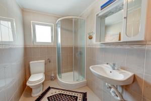 a bathroom with a toilet and a sink and a shower at Veli rat apartments in Savar
