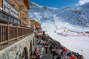 a crowd of people standing outside of a ski resort at Hôtel Le Levanna by Les Etincelles in Tignes