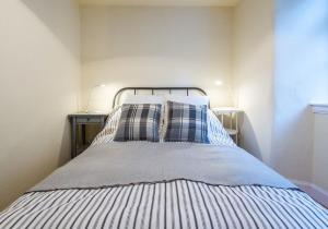 a bed with blue and white sheets and pillows at Number 70 in Haddington