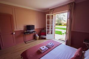 ein Schlafzimmer mit einem Bett mit zwei Handtüchern darauf in der Unterkunft Les jardins de Beaumont in 