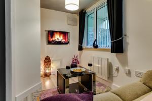 a living room with a couch and a fireplace at 1 Bedroom Swinley Apartment l Free Parking l Wigan Royal Infirmary l Haigh Hall l Central Location in Wigan