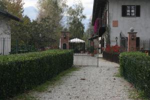 a fence in front of a house with a gate at Agriturismo Cascina Nuova in Barge