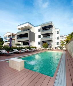 a building with a swimming pool in front of a building at Villa Marija in Sveti Filip i Jakov