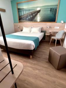 een slaapkamer met een bed en een schilderij van een pier bij The Originals City, Hôtel Le Puech, Narbonne in Narbonne