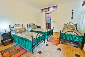 1 dormitorio con 3 camas en una habitación en Riad Al khansaa, en Essaouira