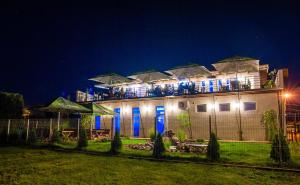 a building with blue lights on it at night at Pensiunea La Broscuta in Cîmpia Turzii