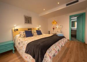 a bedroom with a large bed with a wooden floor at Casas del Castillo Peñíscola-Intramuros Suites in Peñíscola