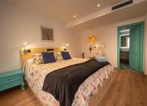 Un dormitorio con una cama grande con suelo de madera. en Casas del Castillo Peñíscola-Intramuros Suites, en Peñíscola