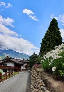 una strada di fronte a un edificio con un albero di Chèvres à Cheval - Apartment ad Aosta