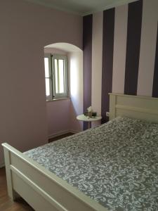 Schlafzimmer mit einem Bett, einem Fenster und einem Spiegel in der Unterkunft Little Yellow House in Rijeka
