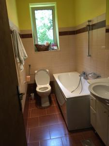 ein Badezimmer mit einer Badewanne, einem WC und einem Waschbecken in der Unterkunft Little Yellow House in Rijeka