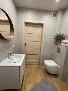 a bathroom with a sink and a toilet and a mirror at Sunny Pobierowo Euronia Apartament in Pobierowo