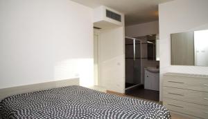 a white bedroom with a bed and a bathroom at Camere e case vacanza Residenza Prealba in Levanto