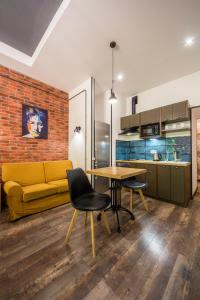 een woonkamer met een gele bank en een tafel bij Loft Design Apartments on Desyatynnyi Ln, 7 in Kiev