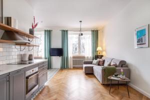 a living room with a couch and a kitchen at Art & Comfort Home in Kaunas