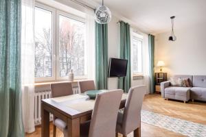 a living room with a table and chairs and a couch at Art & Comfort Home in Kaunas