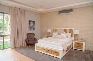 una camera con un letto bianco e una sedia di Masawara Urban Retreat a Harare