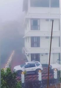 un coche blanco estacionado frente a un edificio en MUNNAR TENT HILLS RESORT, en Devikolam