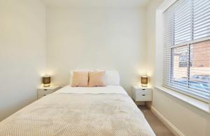 Un dormitorio blanco con una cama y una ventana. en Wearmouth boutique apartment, en Sunderland