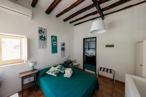 a bedroom with a green bed in a room at Case Vacanza Cafarella in Malfa