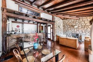 a dining room with a table and chairs and a stone wall at Villa Lidia con piscina by Wonderful Italy in Moniga