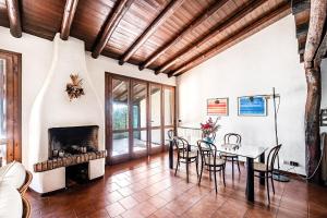 een woonkamer met een tafel en stoelen en een open haard bij Villa Lidia con piscina by Wonderful Italy in Moniga