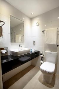 a bathroom with a sink and a toilet and a mirror at Holiday Inn London - Wembley, an IHG Hotel in London