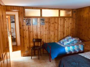 a bedroom with a bed and a chair in it at CASA VACANZE NORA in Chamois