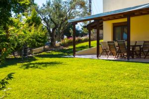 a patio with chairs and a table in a yard at Possidi Villas in Possidi