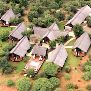 einen Blick über eine Gruppe von Häusern mit Dächern in der Unterkunft Buffalo Thorn Lodge in Pilanesberg