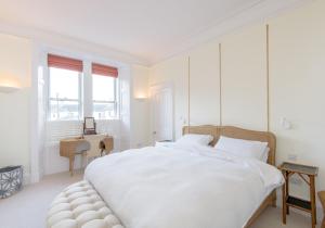 a white bedroom with a large bed and a desk at East Cliff in North Berwick