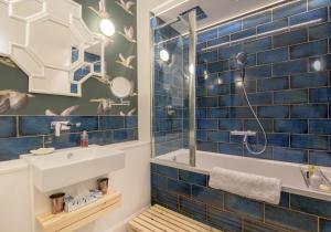 a bathroom with a blue tiled wall and a sink at East Cliff in North Berwick