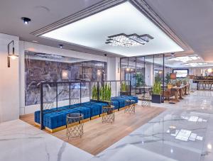 グラナダにあるGran Hotel Luna de Granadaの青い椅子とテーブルのあるロビー