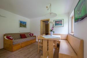 una sala de estar con un sofá y una mesa en BAITA CUCOL: APPARTAMENTO CON GIARDINO PRIVATO, en Cogolo