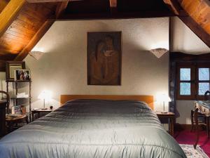 a bedroom with a bed and a painting on the wall at La Maison De Mon Père in Le Nayrac