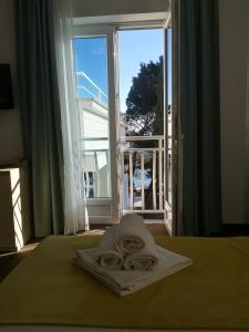a towel on a bed in front of a window at Hotel Bor in Krk