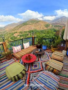 a balcony with a table and chairs and a view of mountains at Atlas Prestige in Imlil